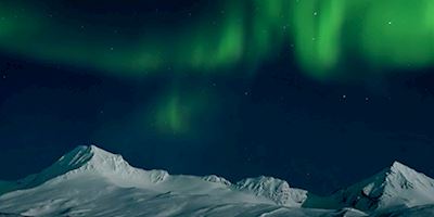 The Northern Lights above snowy mountains