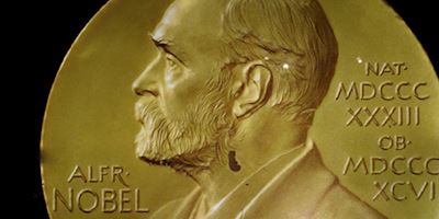 A cropped image of gold embossed with Alfred Nobel's profile and name.
